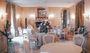 a dining room with tables and chairs and a fireplace at Ecrin de Lumière in Campsegret