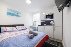 a small bedroom with a bed and a microwave at Hillcrest Studio Apartments in Cleethorpes