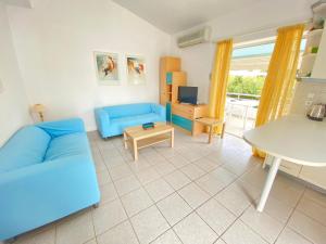 un soggiorno con un divano blu e un tavolo di Aegean breeze apartment by Zen Realty management a Pefkohori