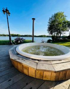 a large fountain on a wooden deck next to the water at AGUONA ROYAL OASIS in Molėtai