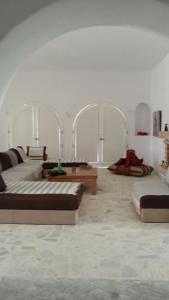 een woonkamer met 3 bedden en een tafel bij Suite Aurora Villa Naïa Domaine Béluga in Sidi el Moujahed