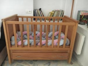 a crib with balls in it with a book shelf at Suite Aurora Villa Naïa Domaine Béluga in Sidi el Moujahed