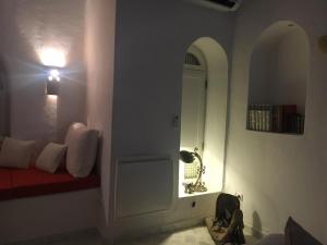 Habitación con puerta blanca, banco rojo y lámpara en Suite Aurora Villa Naïa Domaine Béluga en Sidi el Moujahed