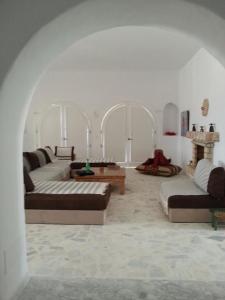 a living room with three couches and a table at Suite Aurora Villa Naïa Domaine Béluga in Sidi el Moujahed