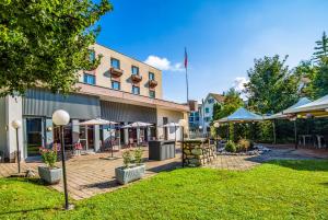 a hotel with tables and umbrellas in a courtyard at Hotel Sursee in Sursee