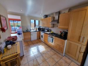 a kitchen with wooden cabinets and a tile floor at Entire house with parking, centrally located & close to Aviva Stadium in Dublin