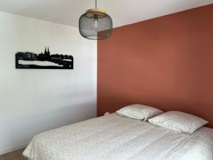 a bedroom with a bed and a wall at Appartement bayonne ellaia in Bayonne