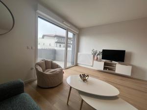 uma sala de estar com um sofá, uma mesa e uma televisão em Appartement bayonne ellaia em Baiona