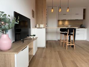 uma cozinha com armários brancos e uma mesa com cadeiras em Appartement bayonne ellaia em Baiona