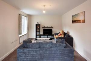 a teddy bear sitting on a couch in a living room at Sea side family rest and holiday in Colwyn Bay