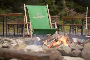 una silla verde sentada junto a un fuego en Wannenkopfhütte, en Obermaiselstein