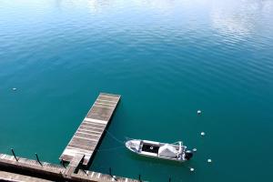a small boat sitting next to a dock in the water at Hotel Restaurant Bellevue au Lac in Thun
