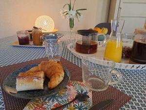 un tavolo con un piatto di pane e succo d'arancia di B&B Côté Loire a Les Rosiers