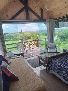 a bedroom with a bed and a view of a patio at Chalé Mirante da Pedra in Serra de São Bento