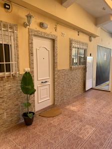 een kamer met een deur en een potplant bij El Faro - Beach in Cullera