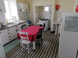 una cocina con una mesa con un mantel rojo. en A Casa da Matriz, en Madalena