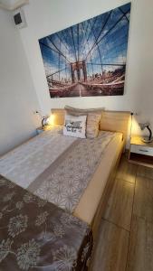 uma cama grande num quarto com uma fotografia na parede em MP Center Magánszállás em Miskolc