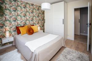 索波特的住宿－Apartament Sopot Kamienny Potok Kujawska，卧室配有一张带彩色枕头的大型白色床。