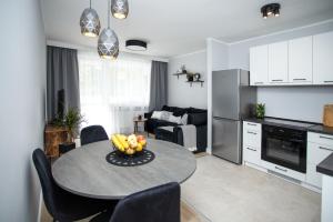 uma cozinha e sala de estar com uma mesa com frutas em Apartament Sopot Kamienny Potok Kujawska em Sopot