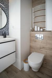 a bathroom with a white toilet and a sink at Apartament Sopot Kamienny Potok Kujawska in Sopot