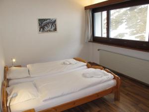 two beds in a room with a window at Residenz Rosablanche, TORTIN SIVI158 in Siviez