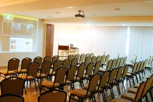 a conference room with a bunch of chairs and a screen at Hotel Pedra Negra Gov. Valadares in Governador Valadares