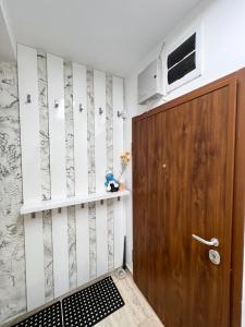 Habitación con puerta de madera y TV en la pared. en Hilton Burgas Holiday Home, en Burgas