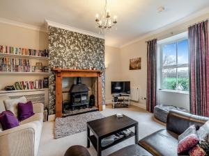 a living room with a fireplace and a tv at Dotty Cottage in Ellingham