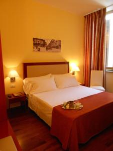 a hotel room with a bed and a table with a tray on it at Hotel Minerva in Milan