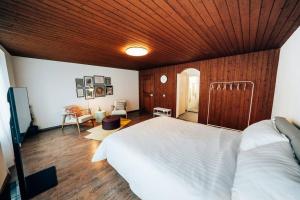 a bedroom with a white bed and a wooden ceiling at theNest Glarus Studio-Apartment in Glarus