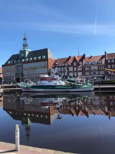 a boat is docked in a harbor with buildings at Zentrale Studio Wohnung in Emden in Emden