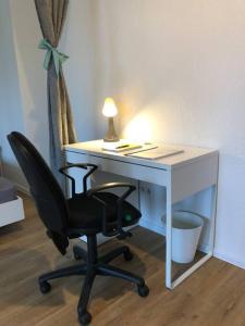 a desk with a chair and a desk with a lamp at Zentrale Studio Wohnung in Emden in Emden
