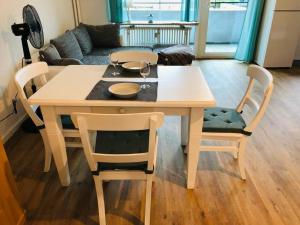 a wooden table and chairs with a table and a couch at Zentrale Studio Wohnung in Emden in Emden +5 photos