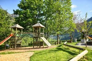 a playground with two swings and a slide at Quadern Apartmenthaus B204 in Bad Ragaz