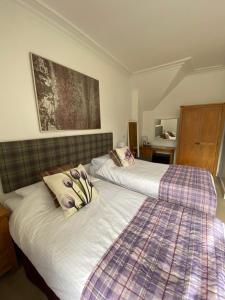 two beds sitting next to each other in a bedroom at Clune House B&B in Newtonmore