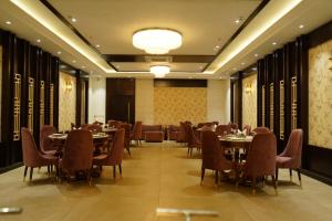 Pura Raghunāth的住宿－HOTEL DHAROHAR，一间在房间内配有桌椅的餐厅