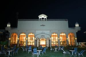 a large building with tables and chairs at night at HOTEL DHAROHAR in Pura Raghunāth