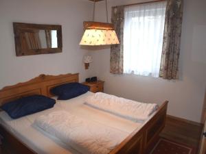 Schlafzimmer mit einem Bett, einem Fenster und einem Spiegel in der Unterkunft Holiday home in Füssen with garden in Füssen