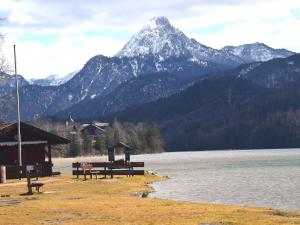 Weissensee holiday home في فوسن: جلسه جبليه بجانب تجمع المياه