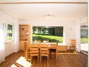 een eetkamer met een tafel en stoelen en een raam bij Urbane Holiday Home in Nesselwang-Reichenbach near Lake in Bayerstetten