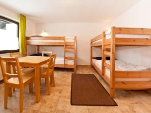 a room with two bunk beds and a table and chairs at Holiday home Reichenbach in Bayerstetten