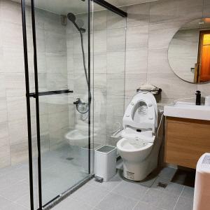 een badkamer met een toilet en een glazen douche bij 小島上二館 in Chung-liu-ts'un