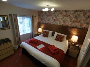a bedroom with a large bed with red towels on it at THE QUORN HOTEL in Blackpool
