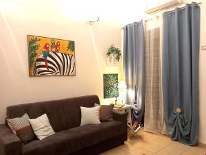 una sala de estar con un sofá marrón y una pintura en Quattro Canti Valù, en Palermo