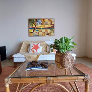 - un salon avec un canapé et une table en verre dans l'établissement Coco Pontall Bangalôs, à Coruripe