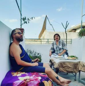 a man and a woman sitting on a patio at Ali Baba Hostel in Jaipur