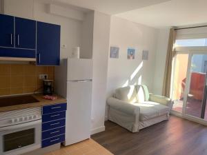 a kitchen with a white refrigerator and a chair at Rosamar Las Canteras Áticos con terraza in Las Palmas de Gran Canaria