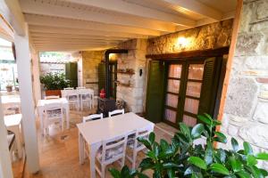 un ristorante con tavoli bianchi e sedie bianche di Perla Rossa Alacati ad Alaçatı