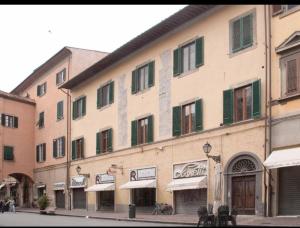 a large building with green windows on a street at CASA BENVENUTI in Pisa
