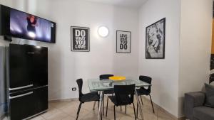 a dining room with a table and a tv on a wall at Casa Iris in Capoliveri